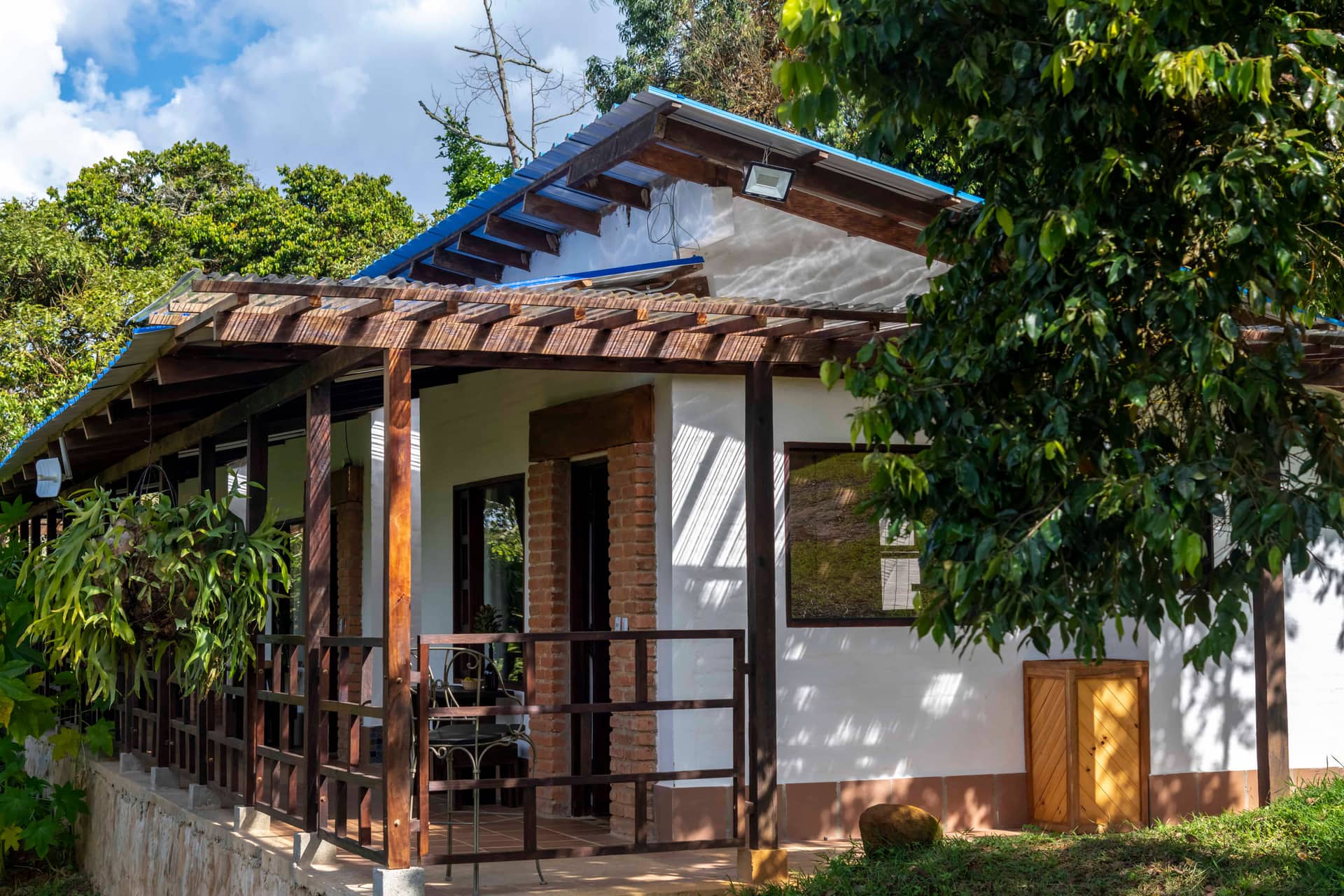 Tres Casitas con su pérgola de madera y techo azul entre la vegetación