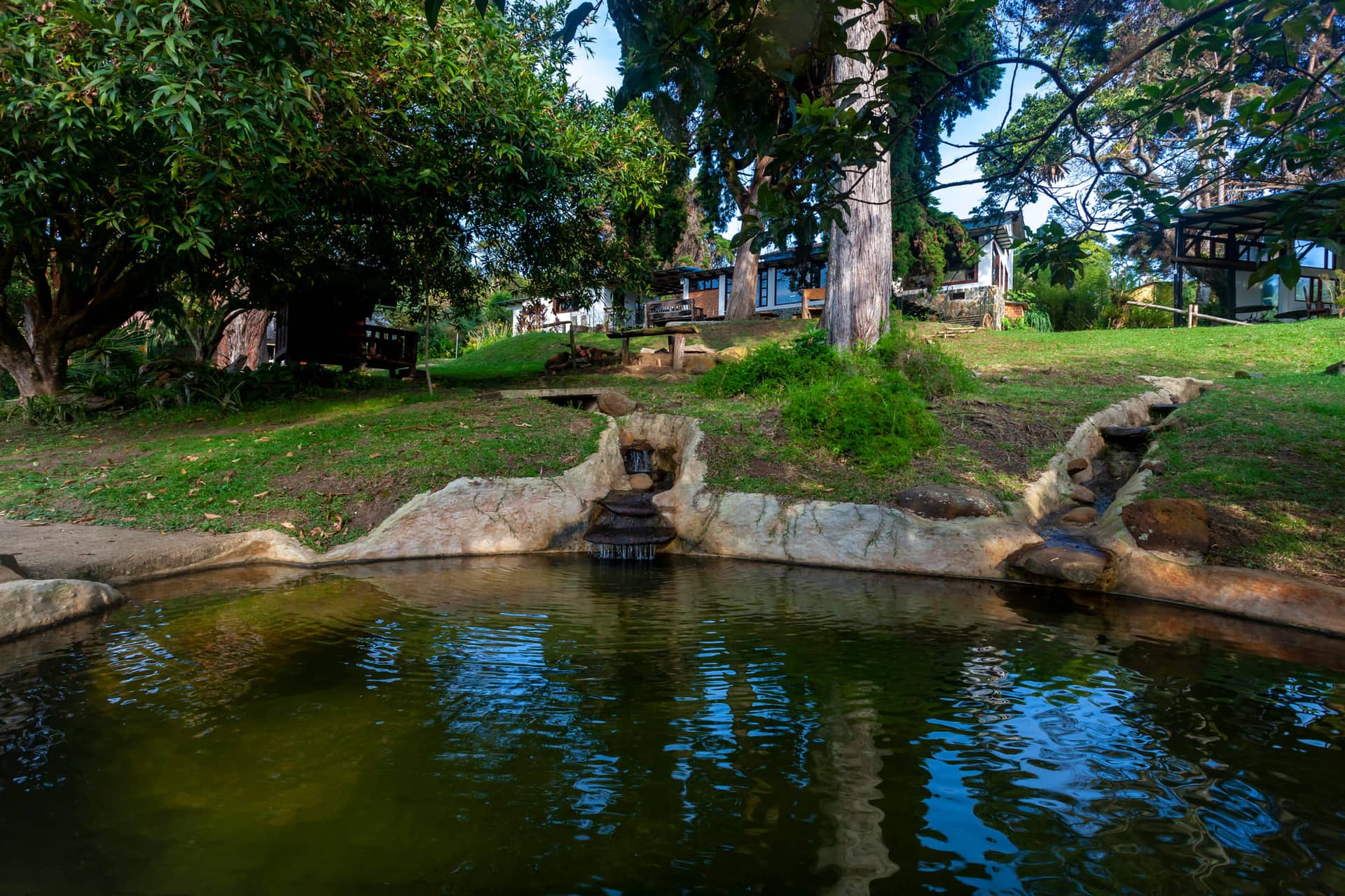 Pileta natural de piedra con la chorrera cayendo al espejo de agua, en las zonas comunes de La Maima